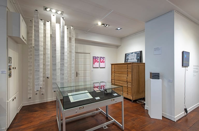 Installation view of “POÈME SBJKT” with works: 1 the Road, 2023 reiteration by Ross Goodwin; Prédelle (here) #2 by Agnès Thurnauer, Grand Dessein by Lillian-Yvonne Bertram, and BIBLIOMECHANICS by Christian Bök. Photography by Jean Louis Losi. Courtesy of the artists